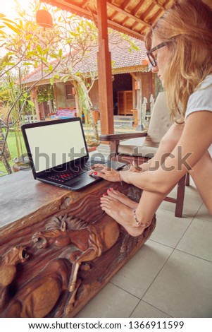Girl using laptop on a home porch / terrace.