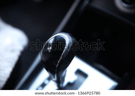 Used , worn gear shift knob close up , heating cooling system on the blurry background.