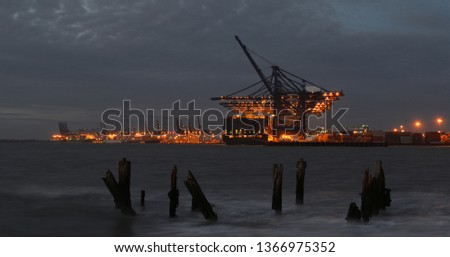 The Lights of the Port of Felixstowe working into the night, cranes loading container ships. Royalty-Free Stock Photo #1366975352