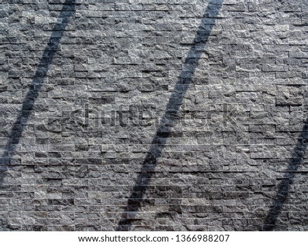 Modern grey brick wall texture background. Shadow shade light on stone brick tiles texture. Minimalist style wall background with copy space.