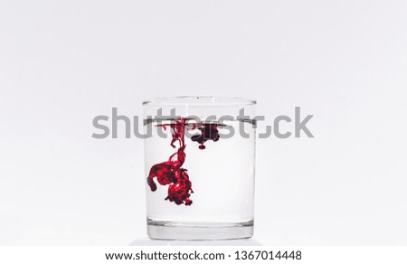 dissolving red paints in a glass