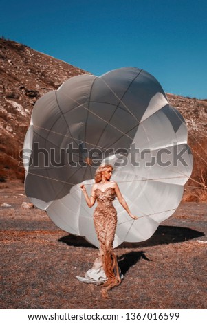 Beautiful female with parachute in nature
