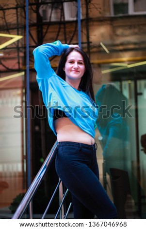 Livestyle portrait of a brunette girl in a blue dwarf toe on the streets of the city of Lvov.Ukraine