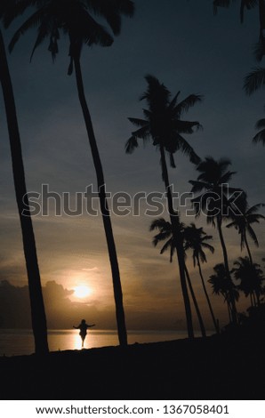 Girl Walking On The Shoreline Enjoying Sunrise at Singaraja Beach, Buleleng, Bali, Indonesia