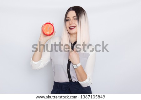 Photo of young blonde businesswoman isolated over white background holding red alarm clock