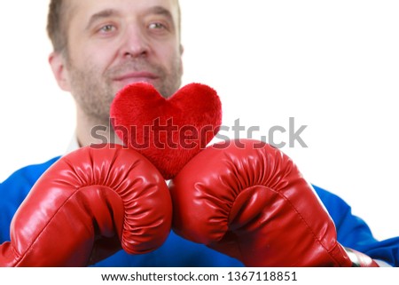 Guy ready to fight for love. Adult man wearing red boxing sporty gloves holding heart shape. Winning with cardiology disease concept.