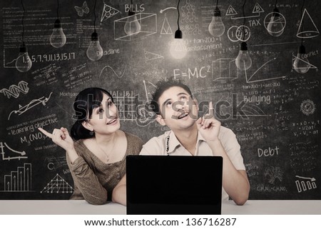 Asian students  looking at solution light bulbs in classroom