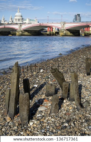 Low tide River Thames and London city skyline including St Paul's Cathedral