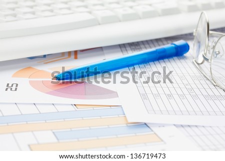 Blue Pen with Spectacles Keyboard and Graphs 