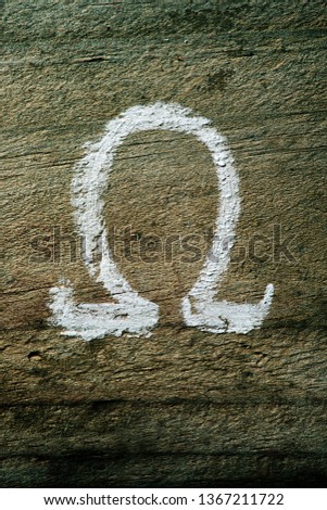 closeup of an omega letter painted with chalk on a rustic wooden surface