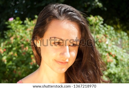 Portrait Of An Young Woman with Golden Reflections on a Nature Background.
