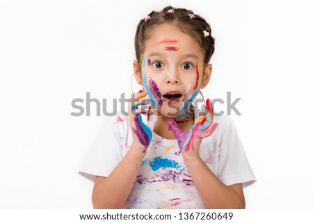 cute surprised little child girl with hands painted in colorful paint isolated on white background.