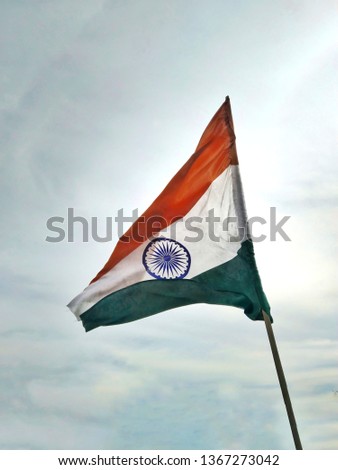 Indian flag waving against beautiful blue sky. National Flag of India. Indian flag from Lower view/angle. Shiny flag.
