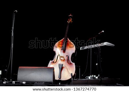 Cello (violoncello) in the center of an empty stage at a concert
