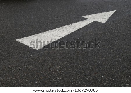 Closeup of arrow on asphalt ground of the parking lot after raining. The traffic sign show the symbol of safty and right direction to the goal.