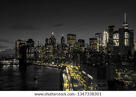 New York City black and white night skyline with golden yellow lights glowing in downtown Manhattan NYC
