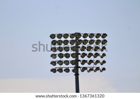 Sports stadium floodlights at day with blue sky