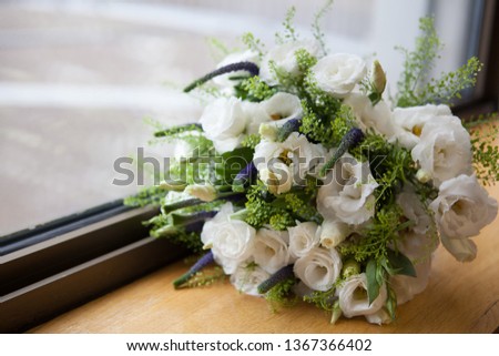 Wedding boutonniere of white roses and green leaves 