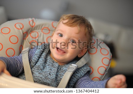 Baby on a feeding chair laughing