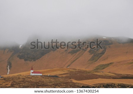 Beautiful scenery of chapel with red roof on the Icelandic valleys with the mist in winter of Iceland
