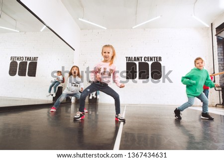 The kids at dance school. Ballet, hiphop, street, funky and modern dancers over studio background. Children showing aerobic element. Teens in hip hop style. Sport, fitness and lifestyle concept.