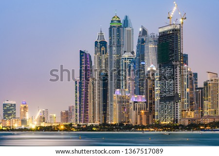 Stunning view of the illuminated Dubai Marina skyline during sunset. Picture taken from the  Palm Jumeirah artificial archipelago. Dubai Marina, Dubai, United Arab Emirates.
