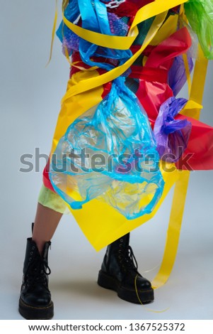 Plastic on body. Close up of female model wearing black leather boots wearing plastic on body