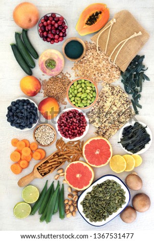 High fibre food for good health with fruit, vegetables, seeds, nuts, cereals and whole wheat pasta. Full of antioxidants, anthocyanins, vitamins and omega 3. Top view on rustic background. Royalty-Free Stock Photo #1367531477