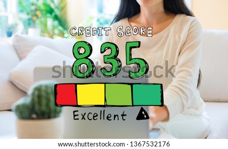Excellent credit score theme with woman using her laptop in her home office