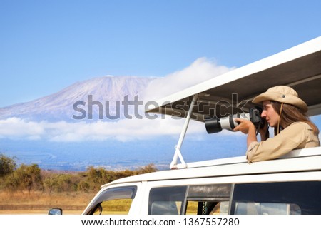 Woman taking shots during Kenyan safari game drive