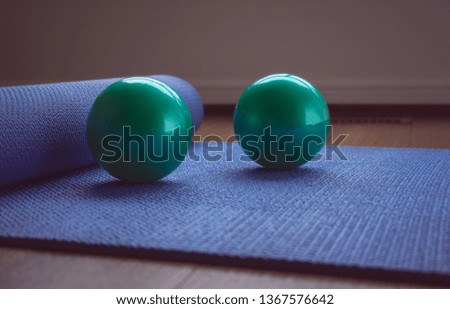 Yoga mat and balls with pastel background 