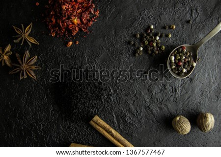A set of spices on a dark stone background.