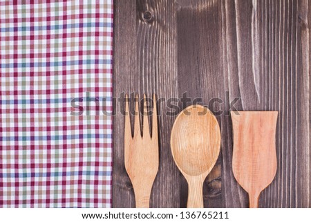 Checkered tablecloth, fork, spoon on wood background