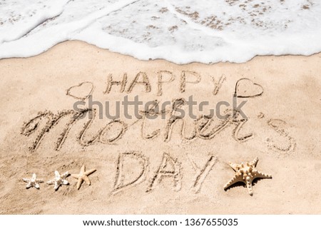 Happy Mother's day background on the sandy beach near the ocean. Hand drawn lettering typography