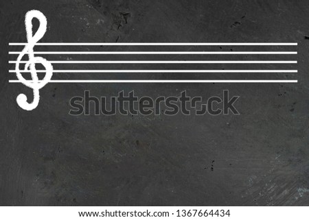 White blank musical five lines staff with violin cleff on it on black chalkboard. Horizontal with copy space for text or design about Music lesson, solfeggio and education, school