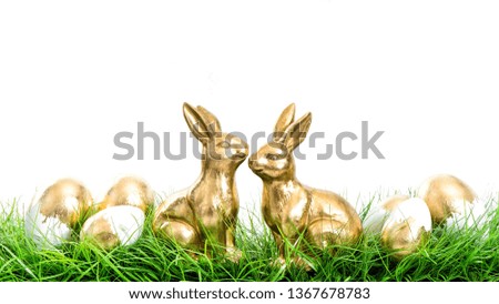 Golden rabbits with Easter eggs decoration on white background