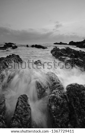 Amazing rock formations at Pandak beach, Terengganu in black and white monochrome fine art technique.  Nature composition blur soft focus noise visible due to long exposure effect. 
