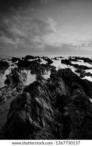 Amazing rock formations at Pandak beach, Terengganu in black and white monochrome fine art technique.  Nature composition blur soft focus noise visible due to long exposure effect. 
