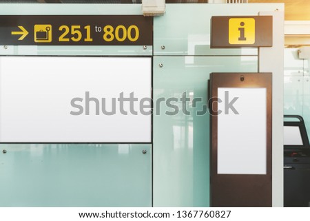 Blank electronic departures and arrival information billboard mockup near a vertical information desk and intercom; an indoor LCD panel placeholder template; a public board in an airport terminal
