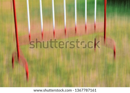 blurry red and white iron barrier on green grass lawn as background
