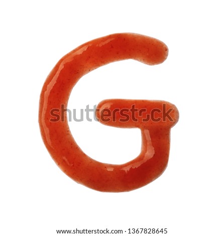 Letter G written with red sauce on white background