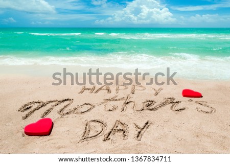 Happy Mother's day background on the sandy beach near the ocean with hearts. Hand drawn lettering typography