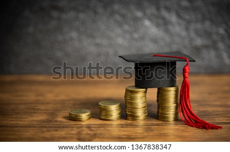 Scholarships education concept with graduation cap on coin money saving  for grants education on wooden table dark background  Royalty-Free Stock Photo #1367838347
