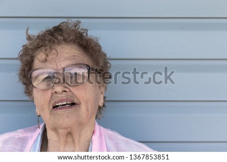 Elderly woman on the background of her home