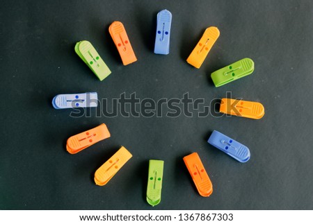 laundry clothes pin arranged in a circle in black background