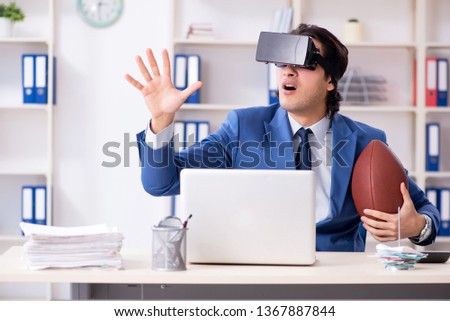 Young handsome businessman playing rugby with virtual glasses