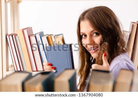 Young female student preparing for exams at library 