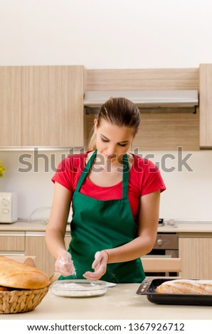 Young female baker working in kitchen 