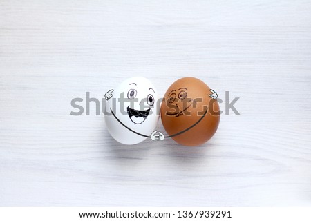 white and colored eggs fun hugging each other. International Friendship Day