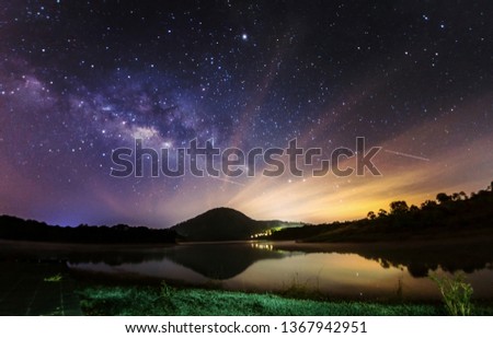 the magic galaxy on the night sky with foreground are mountains and lonely house